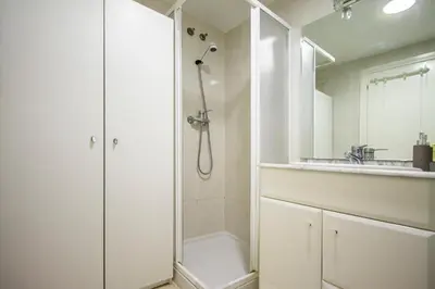 a white bathroom with a shower and a sink at ESPACIO 16 - Primera LINEA PLAYA in Cullera