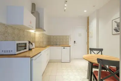 a kitchen with white cabinets and a table with a microwave at Modern Apartment close to City Centre in Valencia