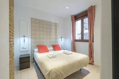 a bedroom with a bed with red pillows and a window at Modern Apartment close to City Centre in Valencia