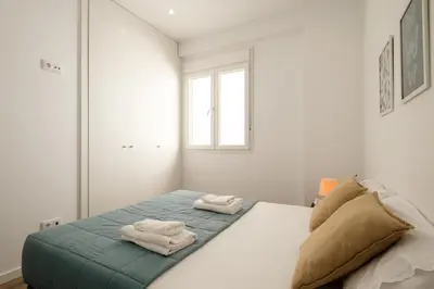 a white bedroom with two towels on a bed at Modern, Stylish Apartment in Valencia