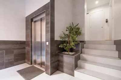 a hallway with stairs and a door with a potted plant at Modern, Stylish Apartment in Valencia