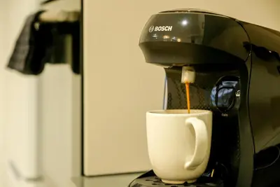a coffee maker is pouring coffee into a coffee cup at Apartment With Super Comfortable Beds in Valencia