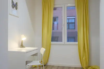 a desk with a lamp and a chair next to a window at Bright, Brand new & Very Comfortable Apartment in Valencia