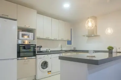 a kitchen with white cabinets and a washer and dryer at Bright, Brand new & Very Comfortable Apartment in Valencia