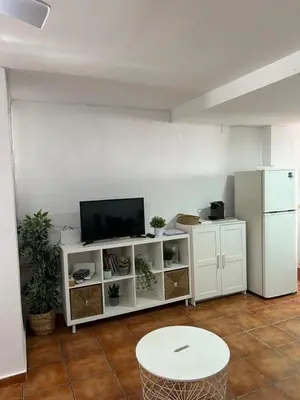 a living room with a table and a tv at Apartamento Casa Quiles in Losa del Obispo
