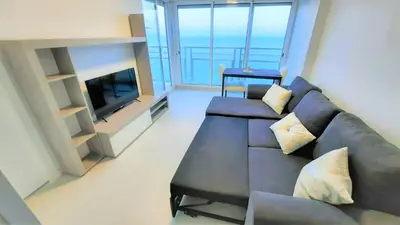 a living room with a couch and a television at Fantastico apartamento Faro de cullera a primera linea mar abierto playa de los olivos in Faro de Cullera