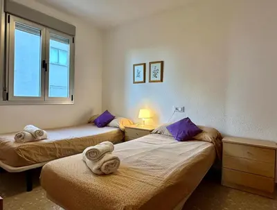 two beds in a room with a window at Large Apartment with Sea Views in Sueca