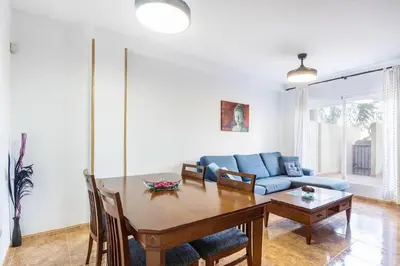 a living room with a table and a blue couch at Balcón del Mar in Canet de Berenguer