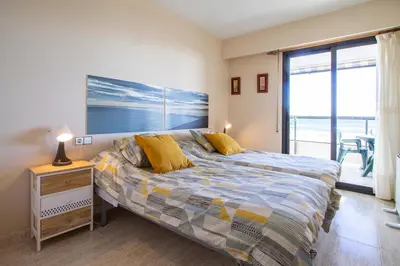 a bedroom with a bed and a view of the ocean at ESPACIO 2 Primera LINEA DE PLAYA in Cullera