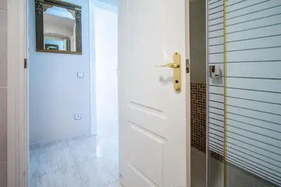 a bathroom with a white door and a mirror at ESPACIO 2 Primera LINEA DE PLAYA in Cullera