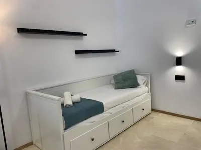 a white bench in a room with a white wall at Travel Habitat La Marina Real in Valencia