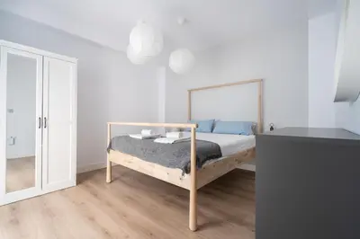 a white bedroom with a bed and a mirror at Casa señorial en el corazón del Puerto by Hometels in Puerto de Sagunto
