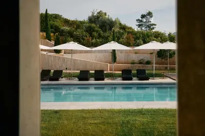 a swimming pool with lounge chairs and umbrellas at La Galiana Golf Resort - Adults Only in Barraca de Aguas Vivas