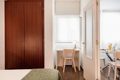 a bedroom with a bed and a table with chairs at Apartamentos FV Flats Valencia - Mestalla 9 in Valencia