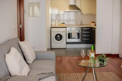 a living room with a couch and a table with wine glasses at Apartamentos FV Flats Valencia - San Felipe Neri in Valencia