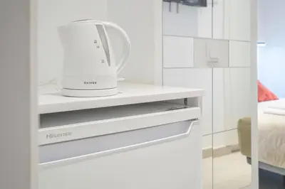 a kitchen with a hair dryer on a shelf at Room close to City Centre in Valencia