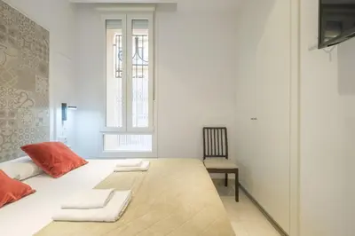 a white room with a large bed and a chair at Room close to City Centre in Valencia