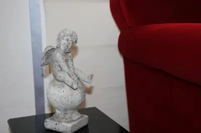 a statue of a girl sitting on a table next to a couch at LUMINOSO. COMODO. ACOGEDOR. WIFI. Junto a AVE in Valencia