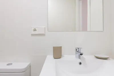 a white bathroom with a sink and a mirror at MD Reina Cabañal Beach in Valencia