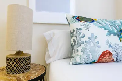 a bed with a pillow and a table with a lamp at MD Reina Cabañal Beach in Valencia