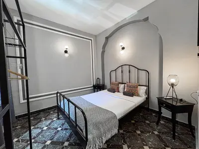 a bedroom with a bed with a black bed frame at The Venue Hostel Boutique in Valencia