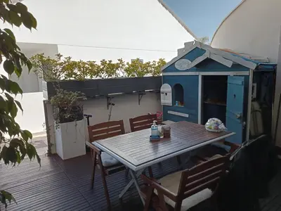 a table and chairs on a deck with a play house at PLAYA ALMARDA,PISCINA,2 TERRAZAS,WIFI,PARKING,BBQ,TRANQUILo in Sagunto