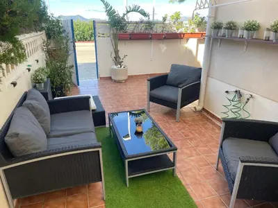 a patio with two couches and a table at PLAYA ALMARDA CORINTO, PISCINA, WIFI,2 TERRAZAS, BARBACOA,TRANQUILo in Sagunto