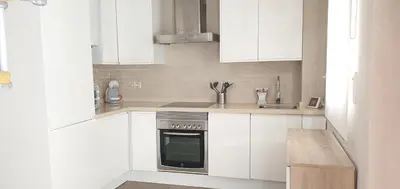 a white kitchen with white cabinets and an oven at Balmes Street in Valencia