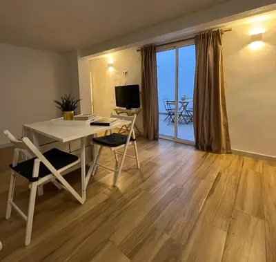 a living room with a table and chairs and a television at Torbellino de Colores in Benaguacil