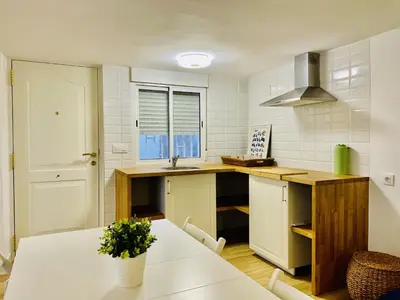 a kitchen with a white counter and a table at Torbellino de Colores in Benaguacil