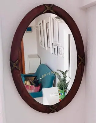 a mirror hanging on a wall with a blue chair at Apartamento Valencia in Catarroja
