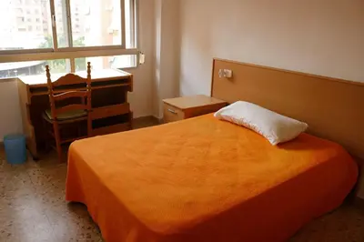 a bedroom with a bed and a desk and a chair at bigger flat for holiday near beach ideal for familie with climatisacion in Valencia