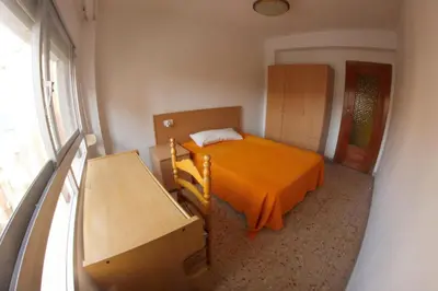 a bedroom with a bed with an orange blanket at bigger flat for holiday near beach ideal for familie with climatisacion in Valencia