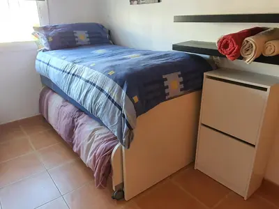 a bed with a blue comforter and a dresser in a bedroom at Apartamento Almenara Nova Almenareta in Almenara