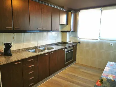 a kitchen with wooden cabinets and a sink at Apartamento a 5 minutos distancia de playa en Puerto de Sagunto -Full Apartment -120m2 in Puerto de Sagunto