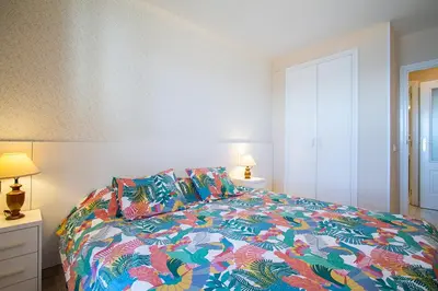 a bedroom with a bed with a colorful comforter and pillows at 13 ESPACIO SOBRE MAR in Cullera