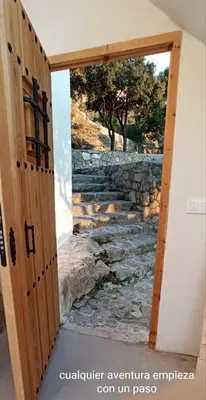 an open door with a stone stairs mural on a wall at La casa alta in Sagunto