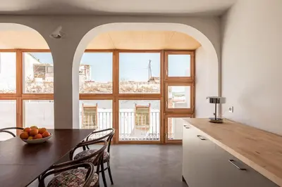 a kitchen with a table and chairs and some windows at La casa alta in Sagunto