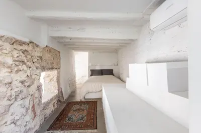 a small room with a bed and a stone wall at La Casa Baja in Sagunto