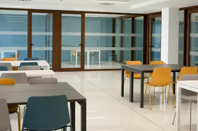 a classroom with tables and chairs and windows at micampus Avenida del Puerto - Residencia de Estudiantes in Valencia