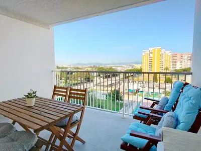 a living room with a table and chairs and a balcony at Global Vacacional, Apartamento nuevo en la playa de Canet d'en Berenguer in Canet de Berenguer