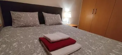 a bed with a red and white towel on it at Cozy Apartment close to the beach in beatiful area in El Perelló