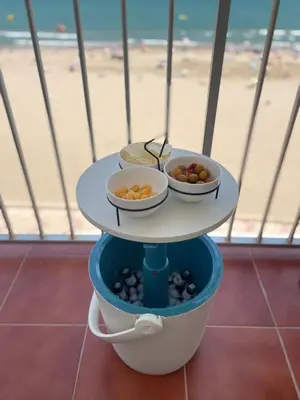 a table with two bowls of food on it next to the beach at Primera línea en Cullera con piscina. Inmejorables vistas in Cullera