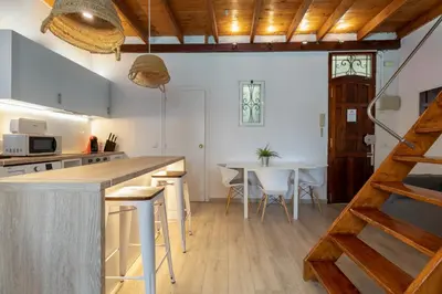 a kitchen and dining room with a counter and a table at Barón Suites Ruzafa in Valencia