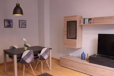 a living room with a table with chairs and a television at Apartment Plaza de la Merced in Valencia