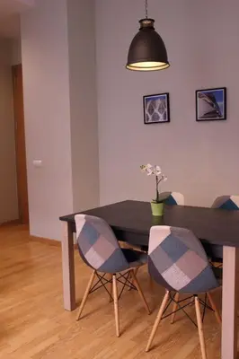 a dining room table with four chairs and a lamp at Apartment Plaza de la Merced in Valencia