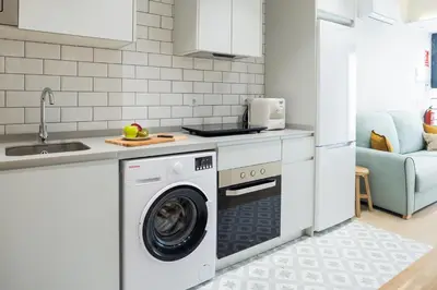 a kitchen with a washing machine and a sink at FLORIT FLATS - The Maritim Serreria Suites in Valencia
