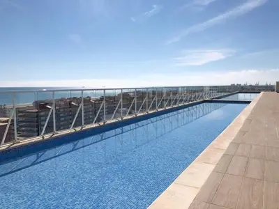 a swimming pool on the roof of a building at Global Vacacional, Moderno apartamento con terraza y vistas al mar in Canet de Berenguer