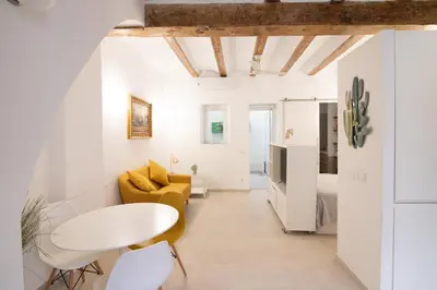 a living room with a yellow couch and a white table at Cabanyal old fisherman's house in Valencia