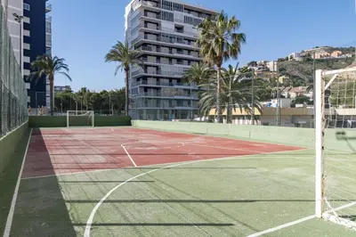 a tennis court with palm trees and a building at Florazar 1, II-A 11-B in Cullera